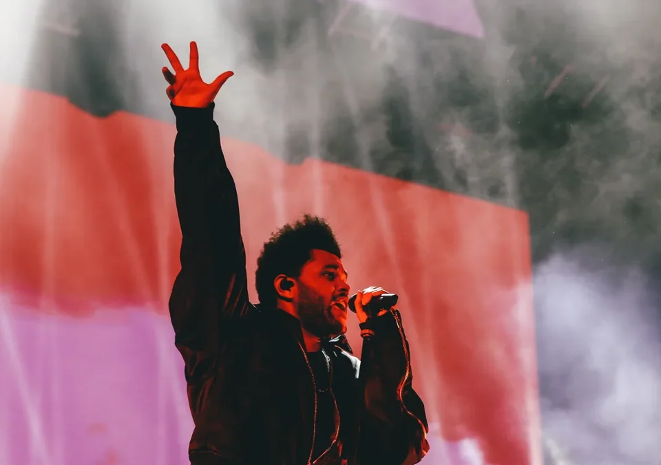 The Weeknd con la mano en alto durante un concierto de su gira