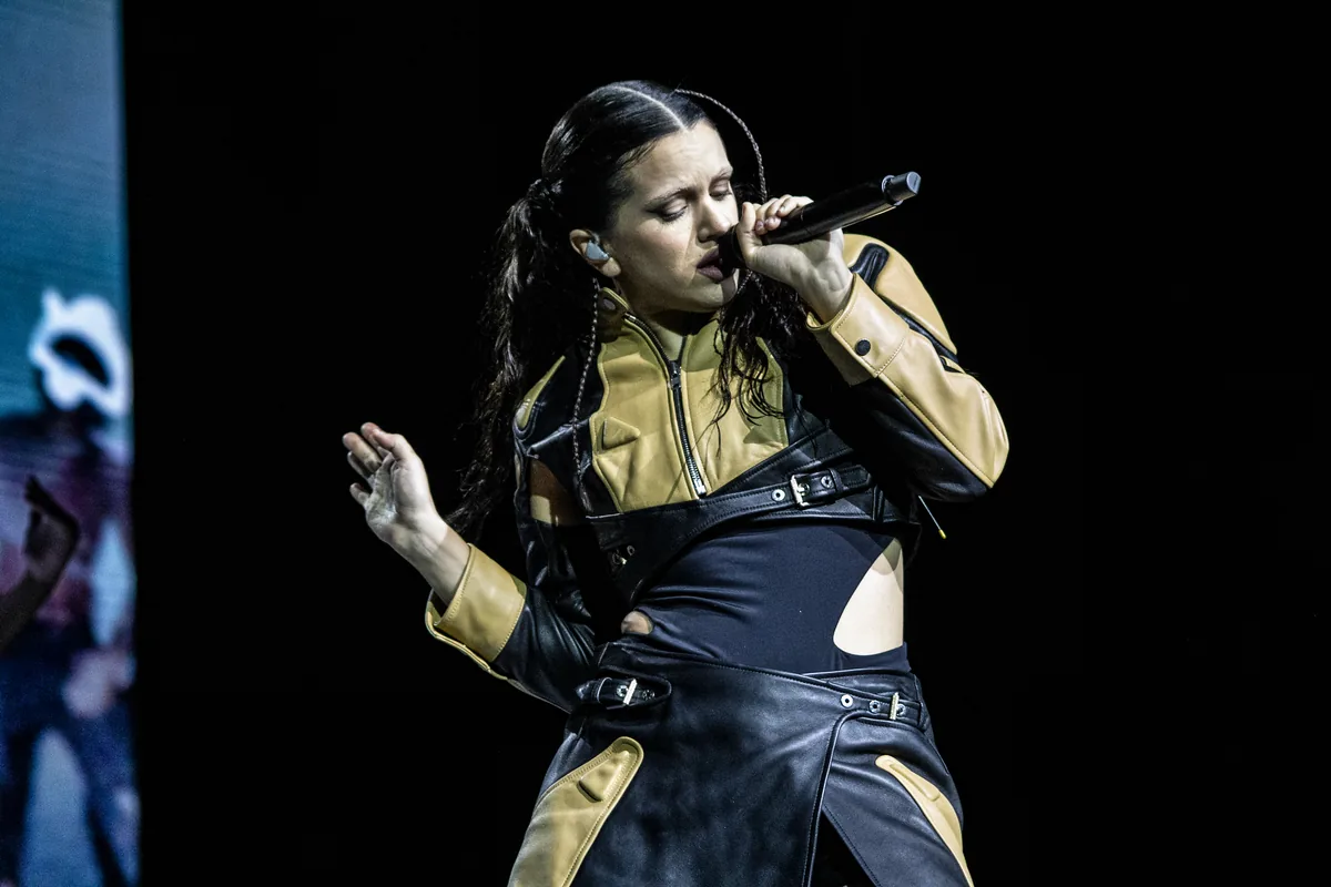 Rosalía cantando con el micrófono en la mano