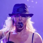 Britney Spears cantando con sombrero negro y micrófono de diadema