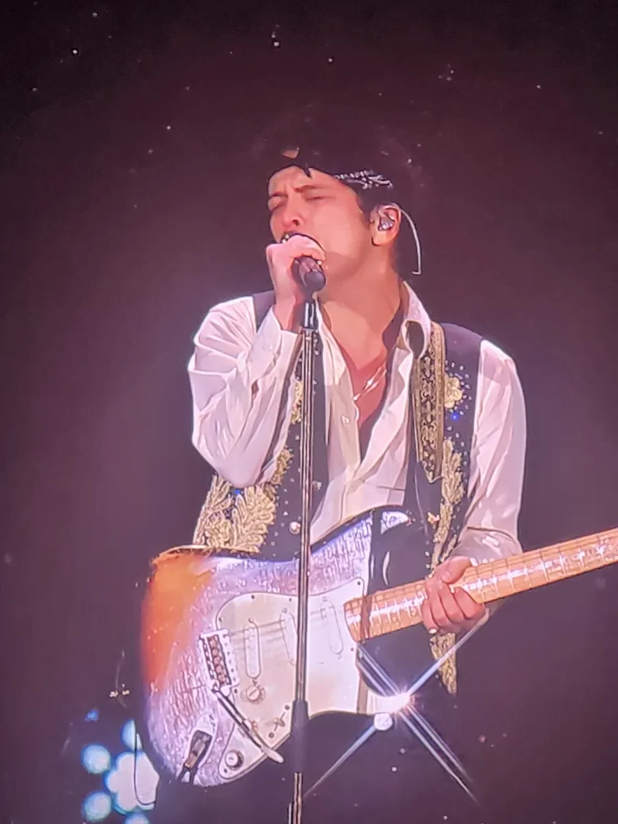 Bruno Mars tocando la guitarra sobre el escenario