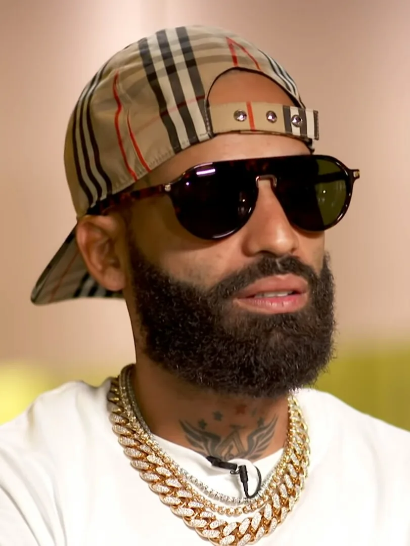 Retrato de Arcángel con gorra de cuadros y gafas de sol durante una entrevista