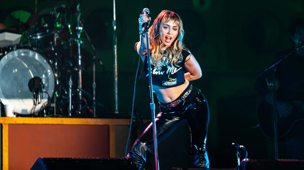 Miley Cyrus agarrada al pie de micro sobre el escenario