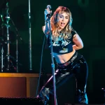 Miley Cyrus cantando en directo con el micrófono en la mano