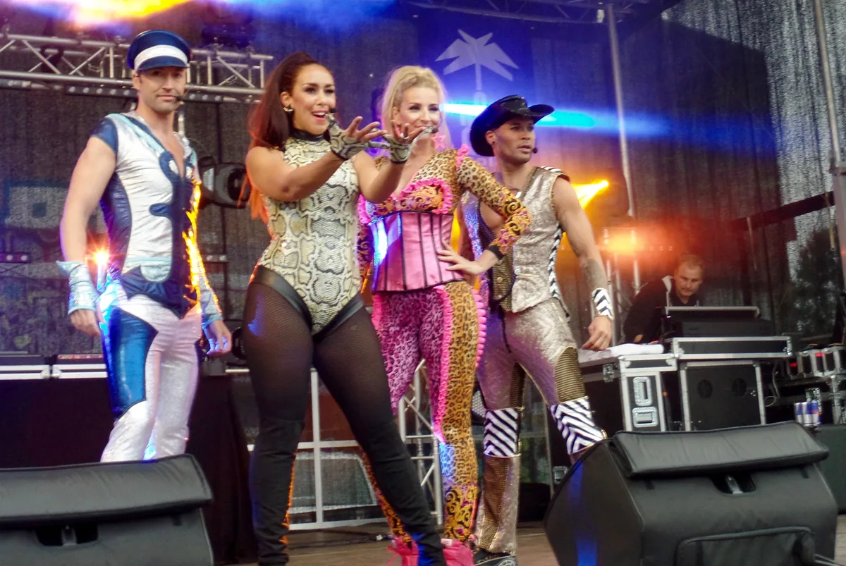 Los Vengaboys actuando sobre un escenario con trajes de colores