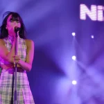 Aitana canta al micrófono durante un concierto