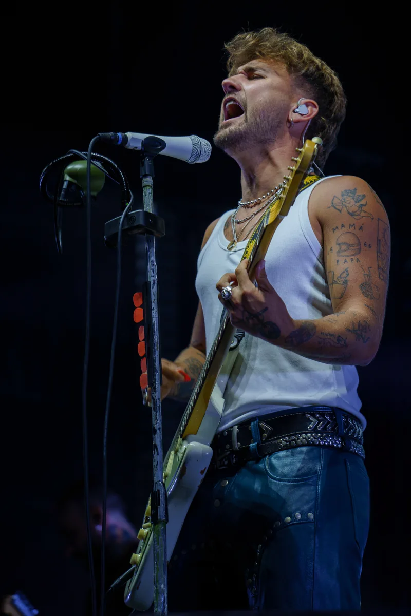 Dani Fernández canta con los ojos cerrados mientras toca la guitarra junto al micrófono