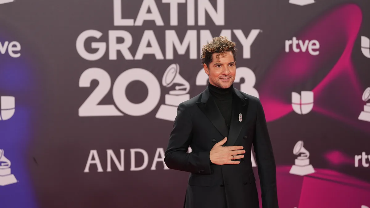 David Bisbal con traje negro y la mano en el pecho en la alfombra roja de los Latin Grammy