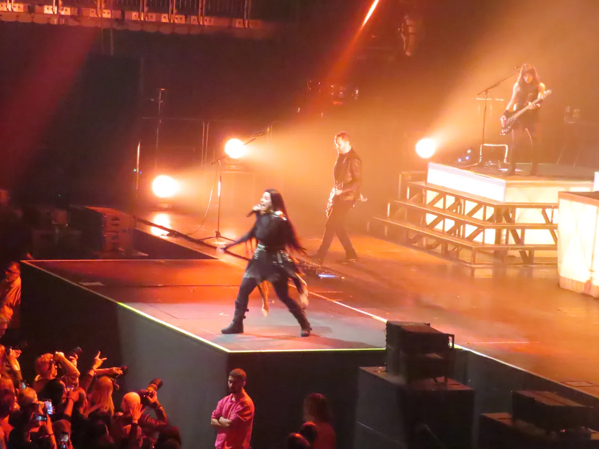 La banda Evanescence tocando sobre un escenario iluminado
