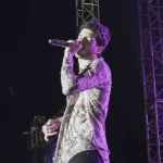 Sebastián Yatra cantando con un micrófono en un concierto al aire libre