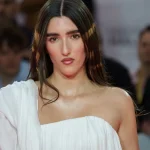 Judeline posa en una alfombra roja con un vestido blanco de un solo hombro
