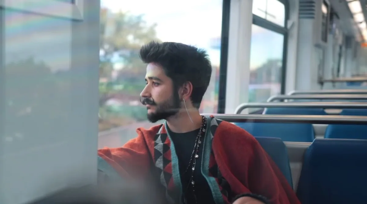 Camilo mirando por la ventanilla de un tren
