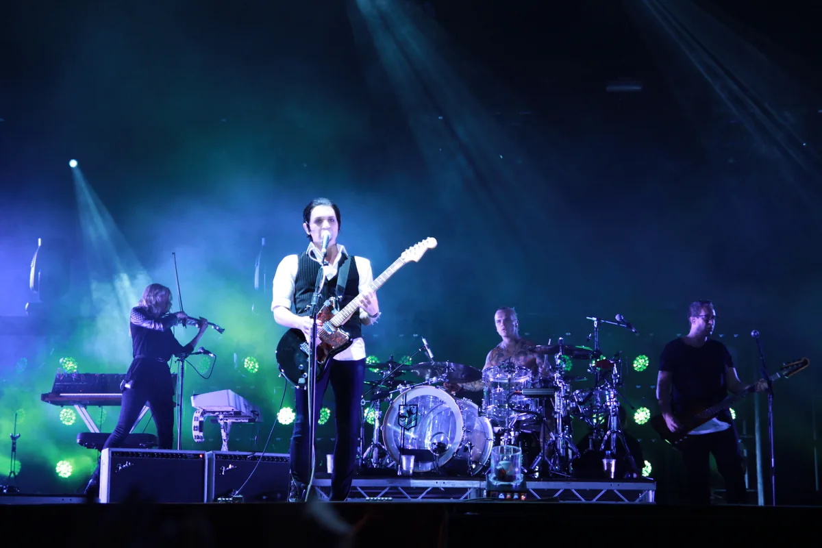 La banda Placebo tocando en directo sobre un escenario