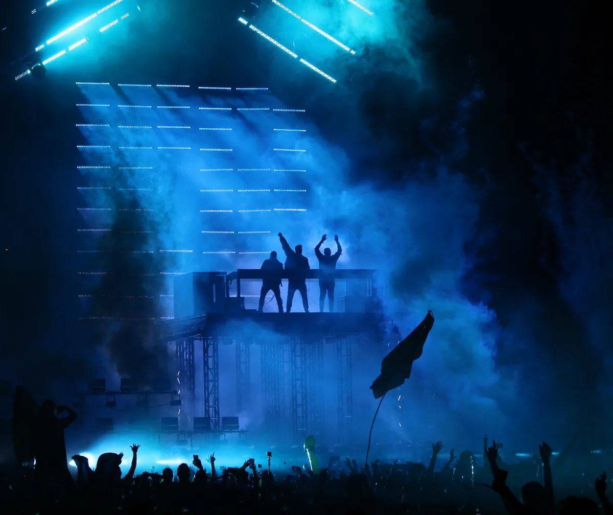 Swedish House Mafia en directo sobre una plataforma entre humo azul