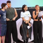 Violeta Hódar leyendo un texto con micrófono en un escenario junto a otros tres concursantes de Operación Triunfo