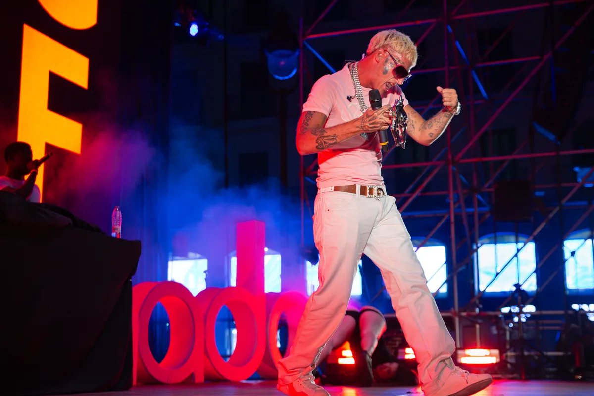 Yung Beef actuando sobre el escenario vestido de blanco