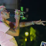 Yung Beef cantando con el brazo extendido hacia el público