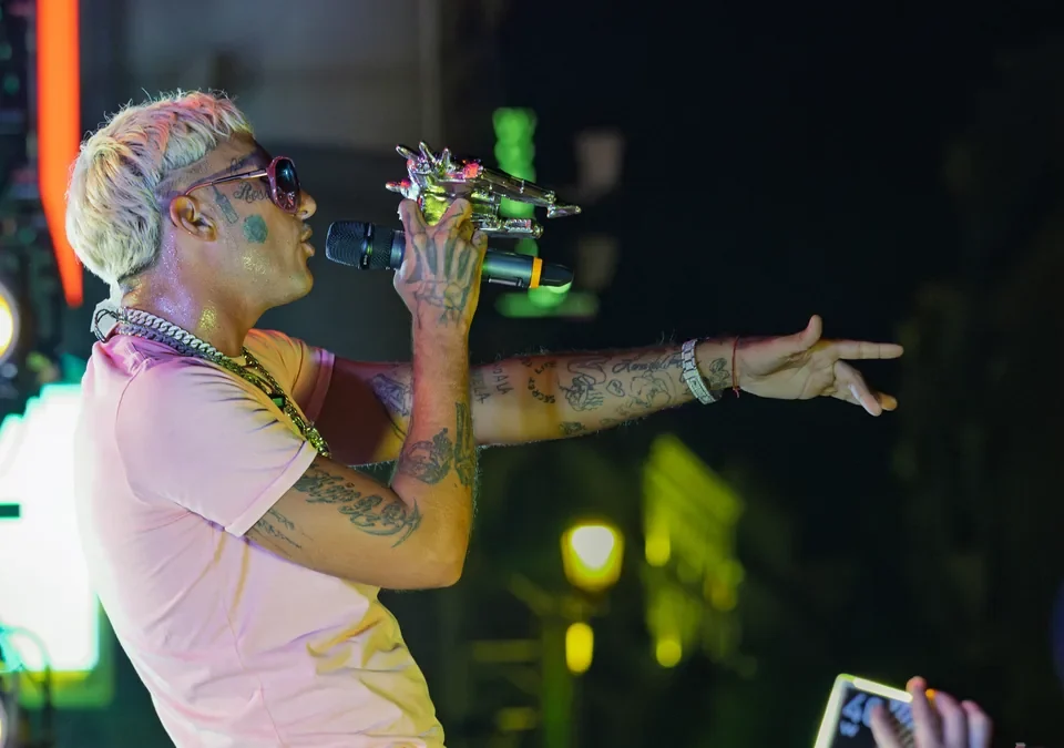 Yung Beef cantando con el brazo extendido hacia el público